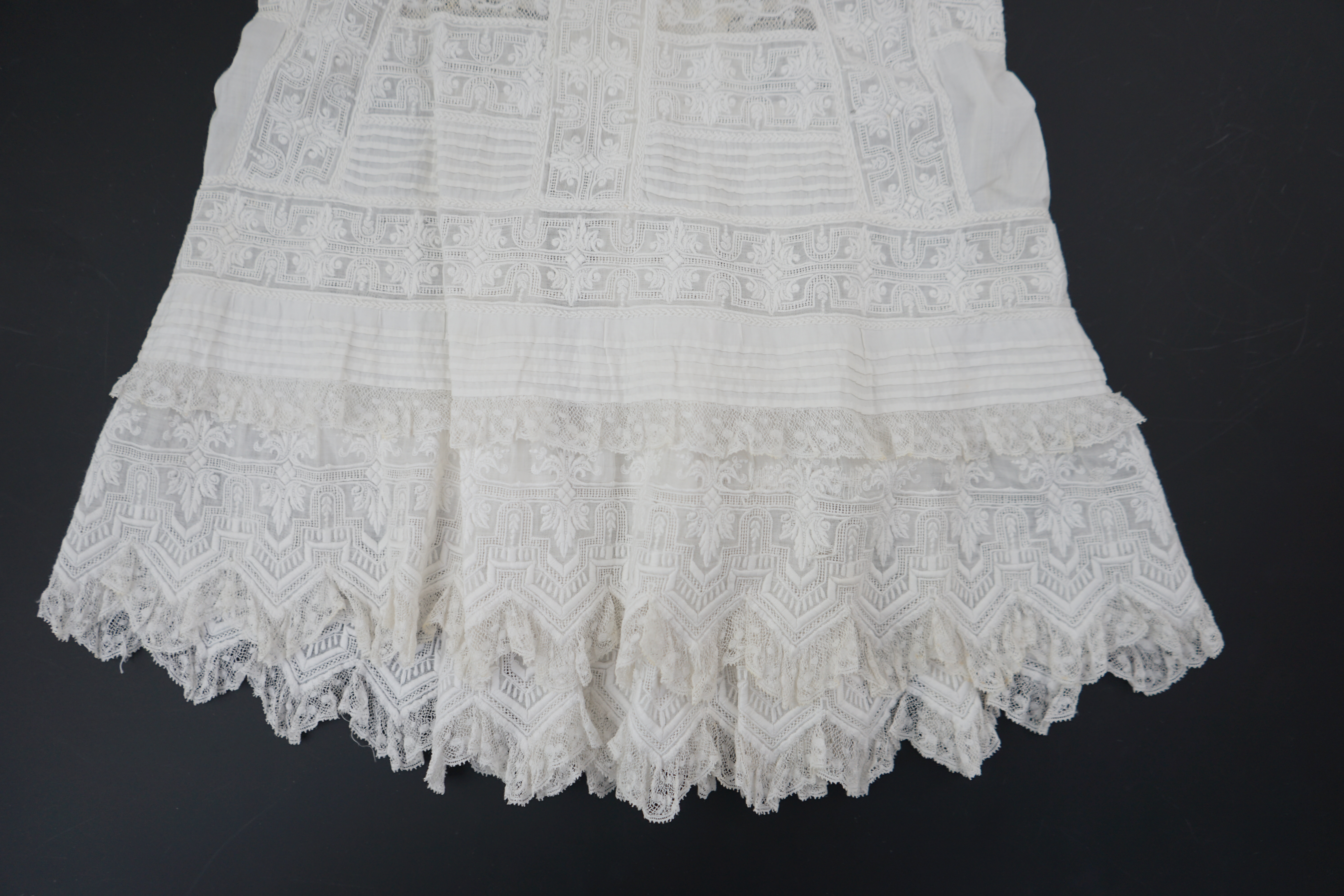 Two unusual 19th century intricately white worked children’s dresses, one hand worked with fine panels of white work, feather stitching and tucking, edged and inserted with hand made Valenciennes lace, the other worked i